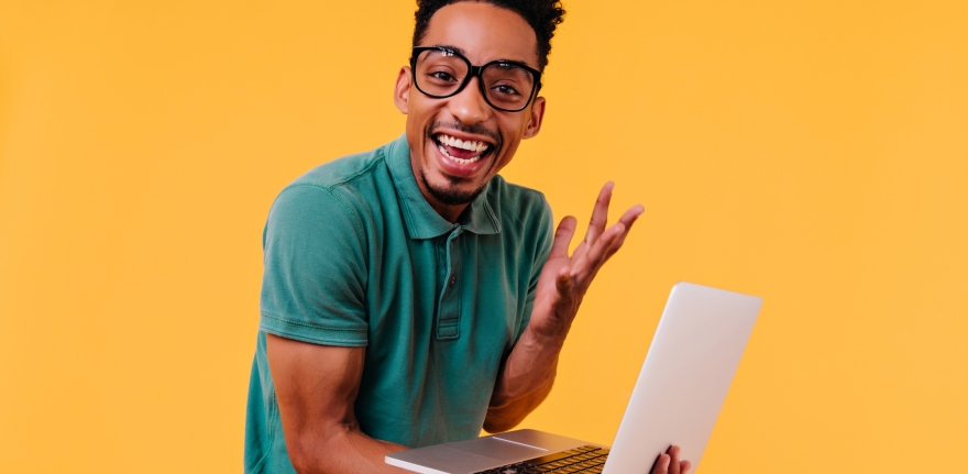 handsome-male-freelancer-glasses-smiling-ecstatic-african-student-holding-laptop-expressing-happiness